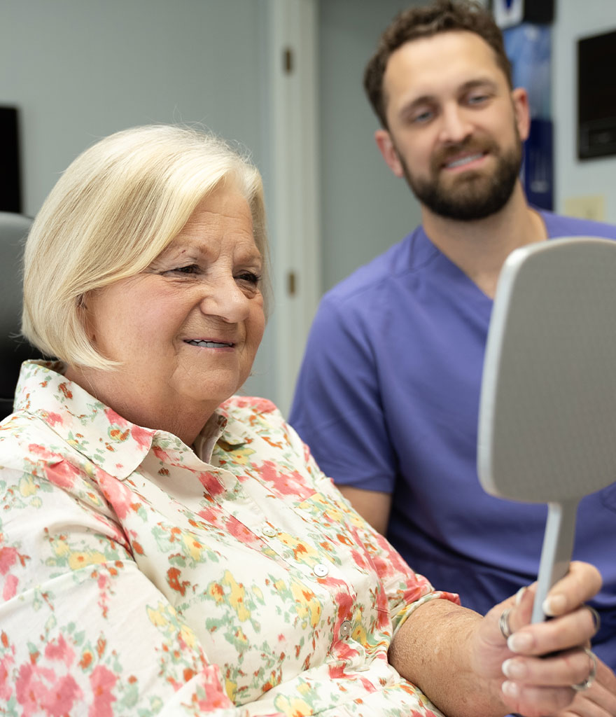 Patient viewing her smile with her dentist